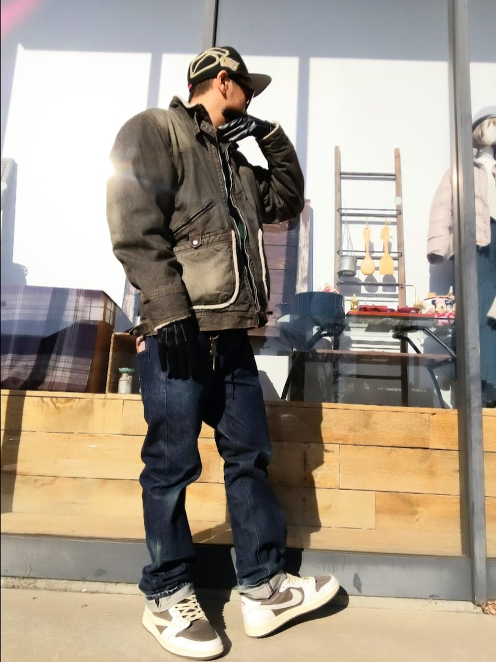 ブラック系のデニムジャケット、グリーン系のスウェット、ブルー系のデニムパンツを着用したメンズの冬コーディネートの2枚目の写真