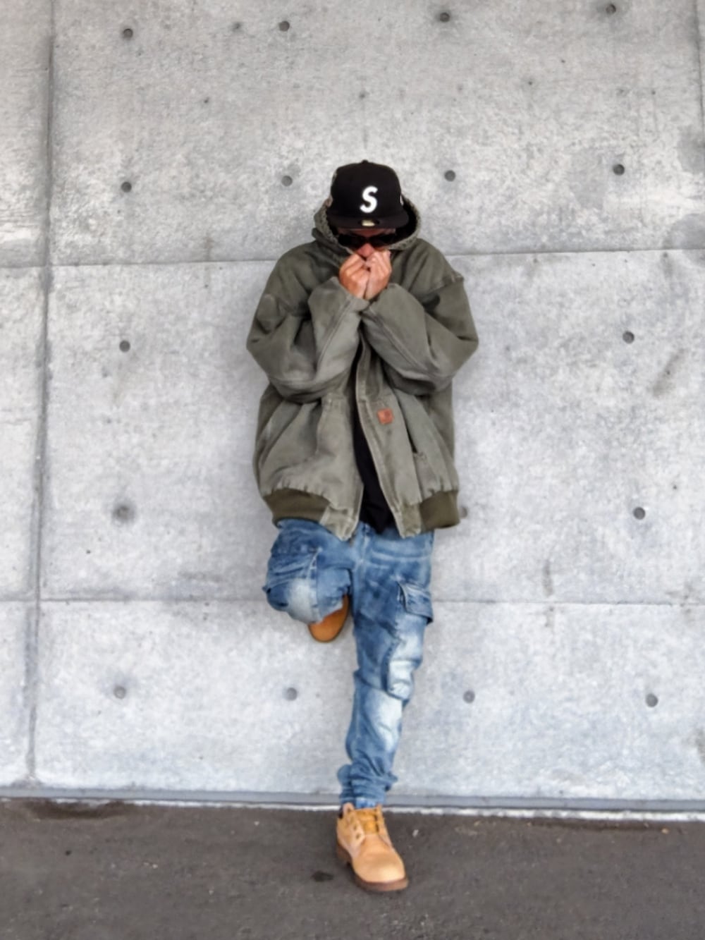 グリーン系のジャケット/アウター、ブラック系のTシャツ/カットソー、ブルー系のデニムパンツを着用したメンズの秋コーディネートの2枚目の写真