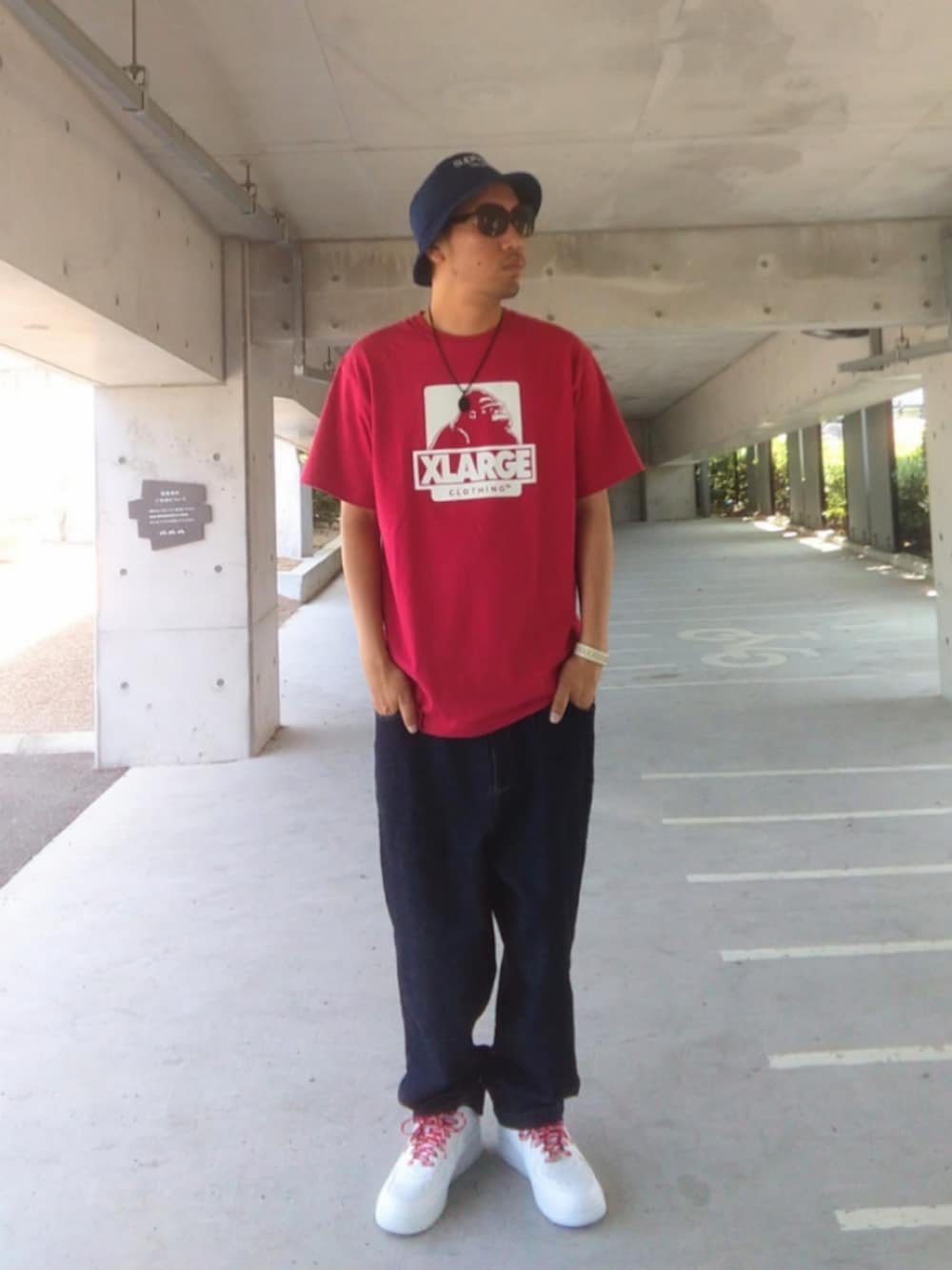 ブラック系のTシャツ/カットソー、ベージュ系のチノパンツ、ブラック系のスニーカーを着用したメンズの夏コーディネートの2枚目の写真