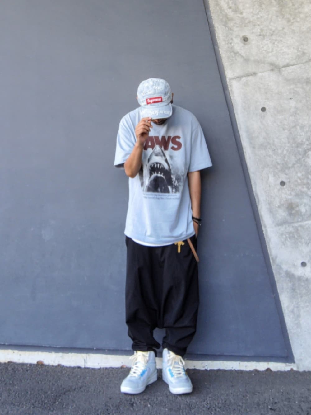 ブルー系のTシャツ/カットソー、ブラック系のその他パンツ、グレー系のスニーカーを着用したメンズの夏コーディネートの2枚目の写真