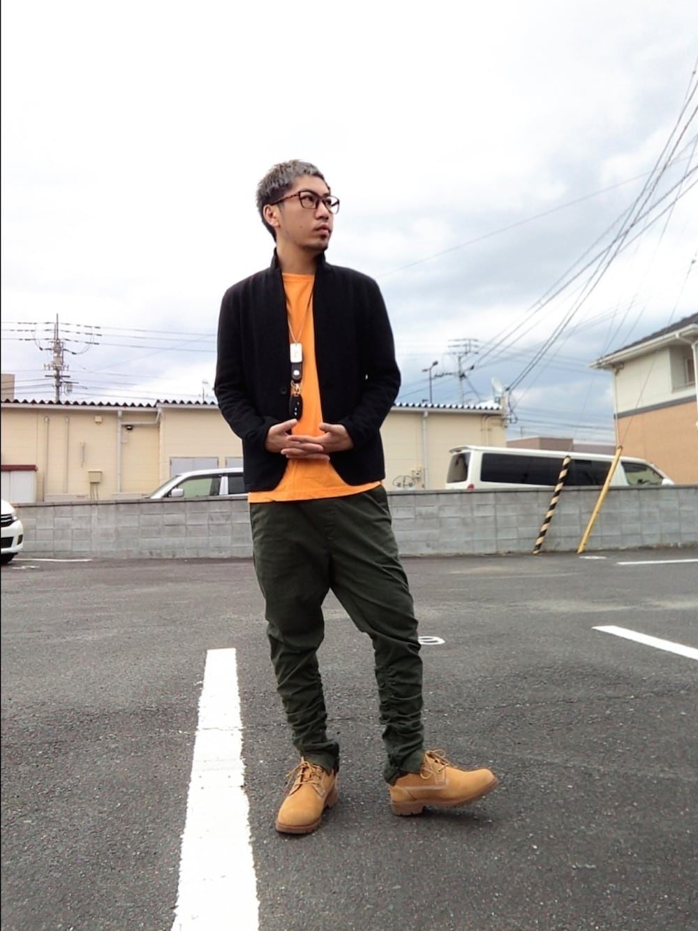 イエロー系のブーツ、グリーン系のパンツ、オレンジ系のTシャツ/カットソーを着用したメンズの冬コーディネートの2枚目の写真