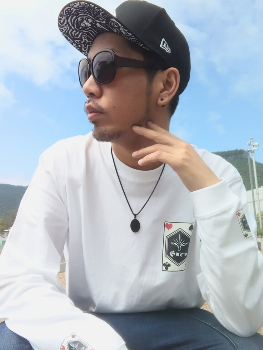 ホワイト系のTシャツ/カットソー、ブルー系のパンツ、ホワイト系のスニーカーを着用したメンズの春コーディネートの4枚目の写真