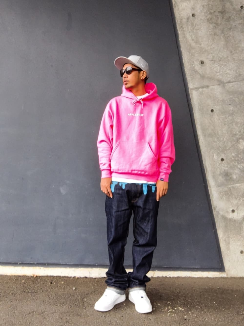ピンク系のパーカー、ブルー系のデニムパンツ、ホワイト系のスニーカーを着用したメンズの秋コーディネートの2枚目の写真