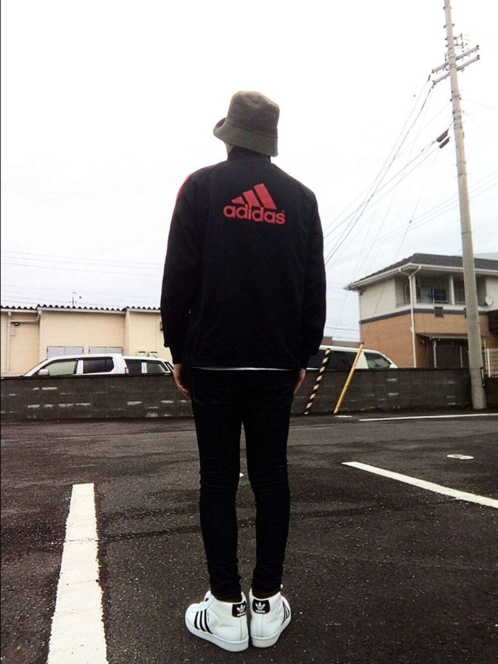 ブラック系のジャージ、ブルー系のデニムパンツ、ホワイト系のスニーカーを着用したメンズの冬コーディネートの3枚目の写真