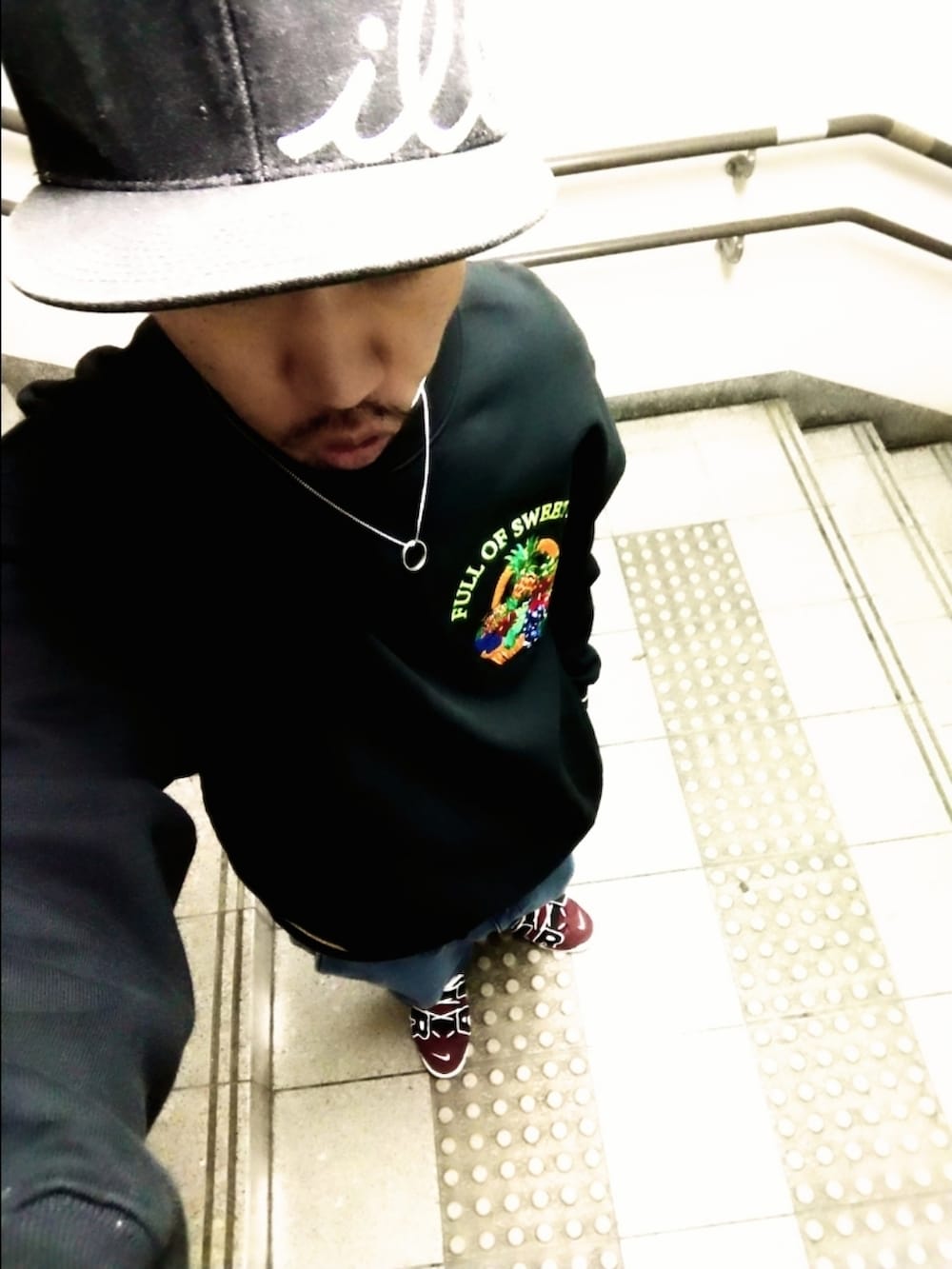 ブラック系のスウェット、ブルー系のデニムパンツ、レッド系のスニーカーを着用したメンズの秋コーディネートの2枚目の写真