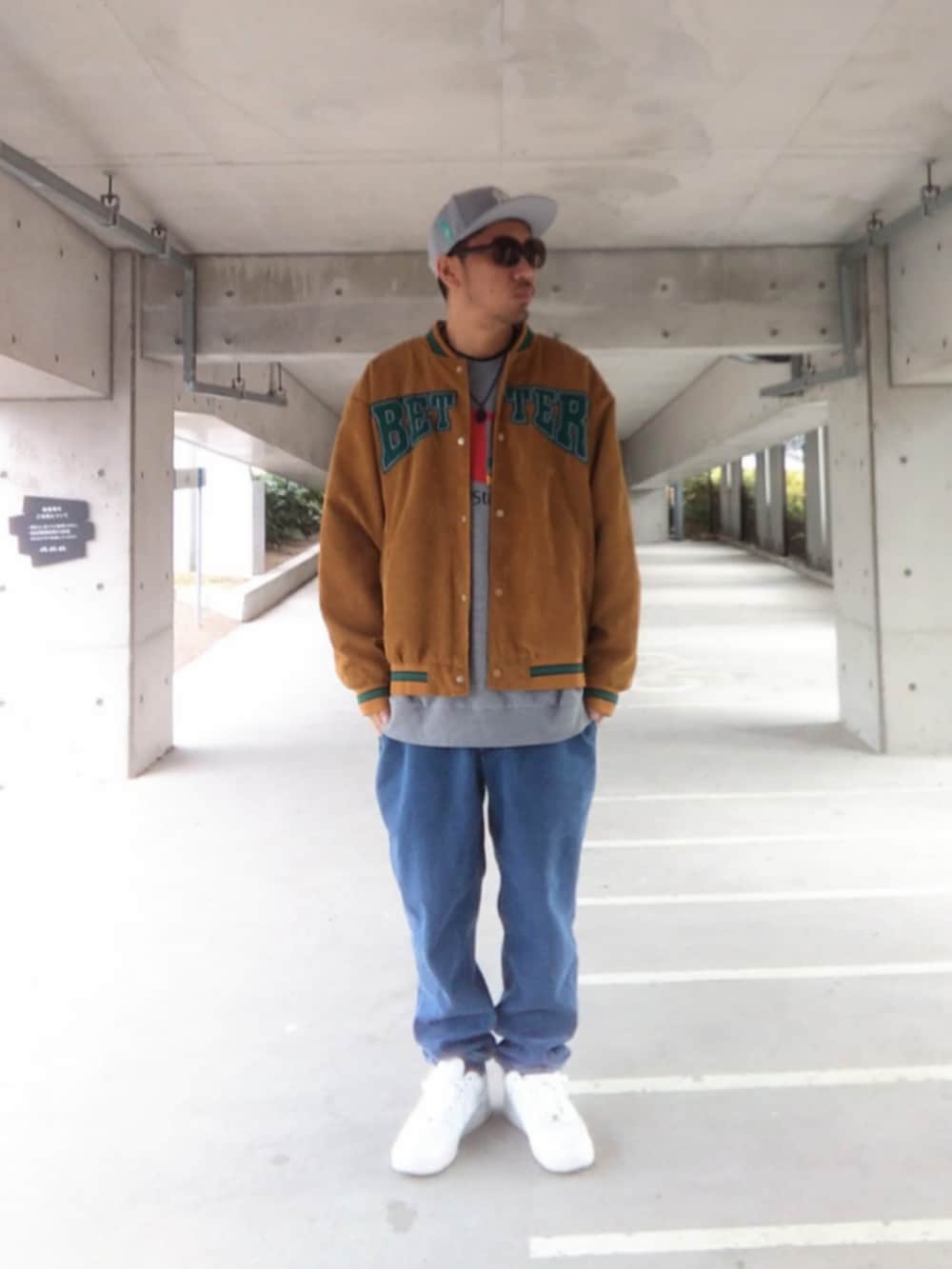 ブラウン系のスタジャン、グレー系のスウェット、ブルー系のデニムパンツを着用したメンズの冬コーディネートの2枚目の写真