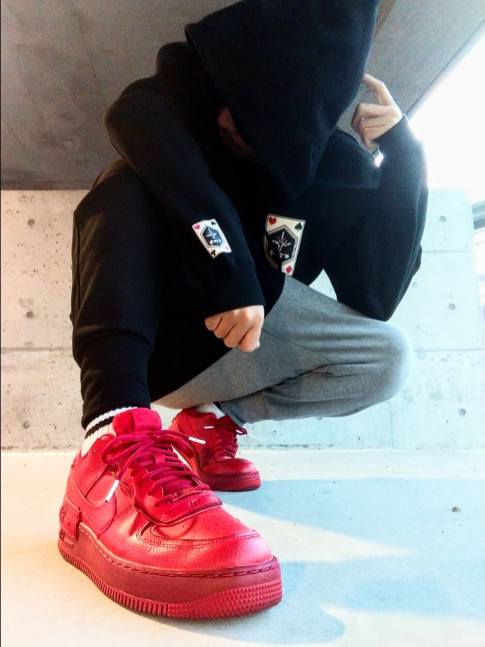 ブラック系のパーカー、レッド系のスニーカー、その他のスウェットパンツを着用したメンズの秋コーディネートの3枚目の写真