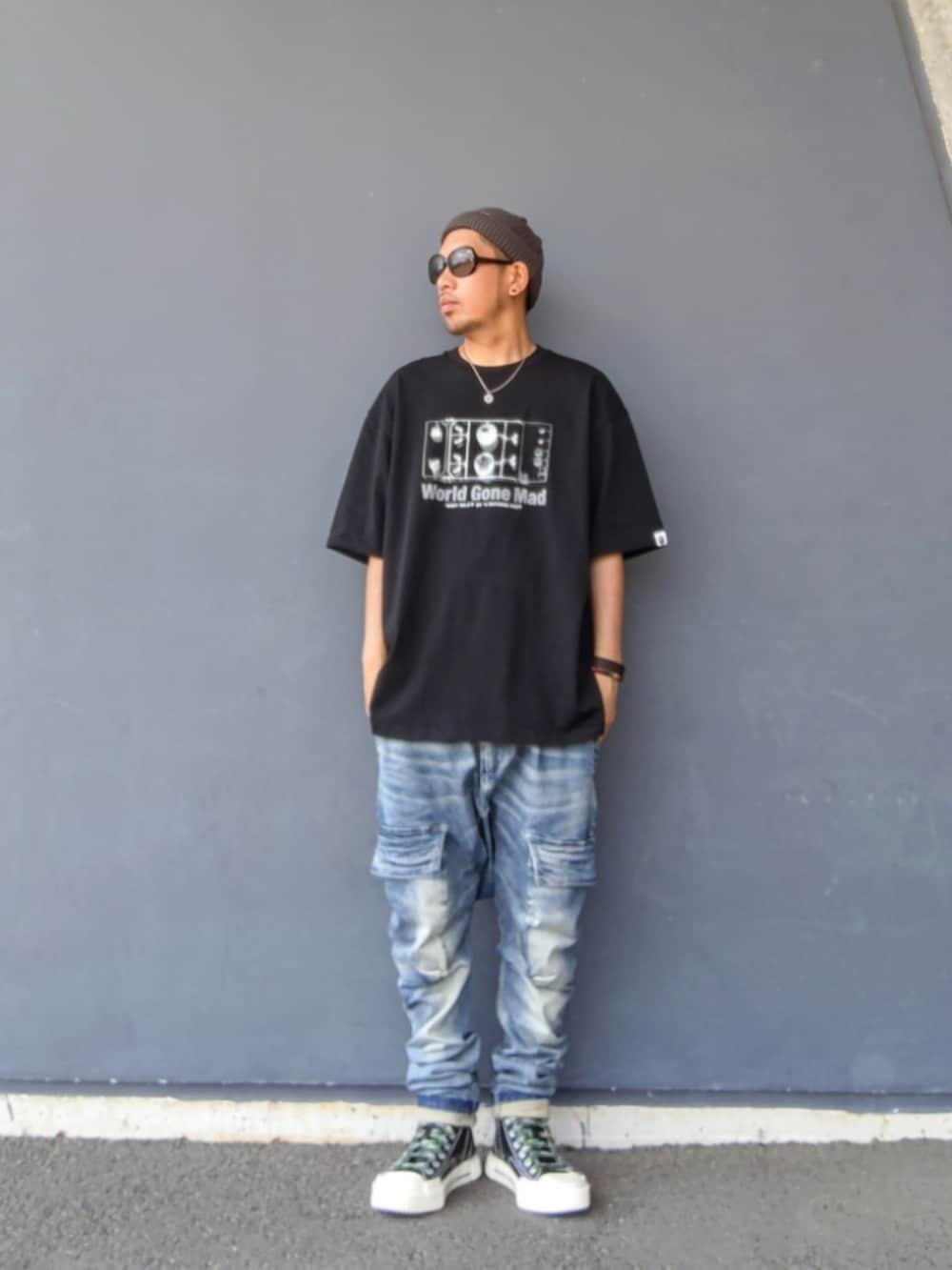 ブラック系のTシャツ/カットソー、ブルー系のデニムパンツ、ブラック系のスニーカーを着用したメンズの夏コーディネートの2枚目の写真