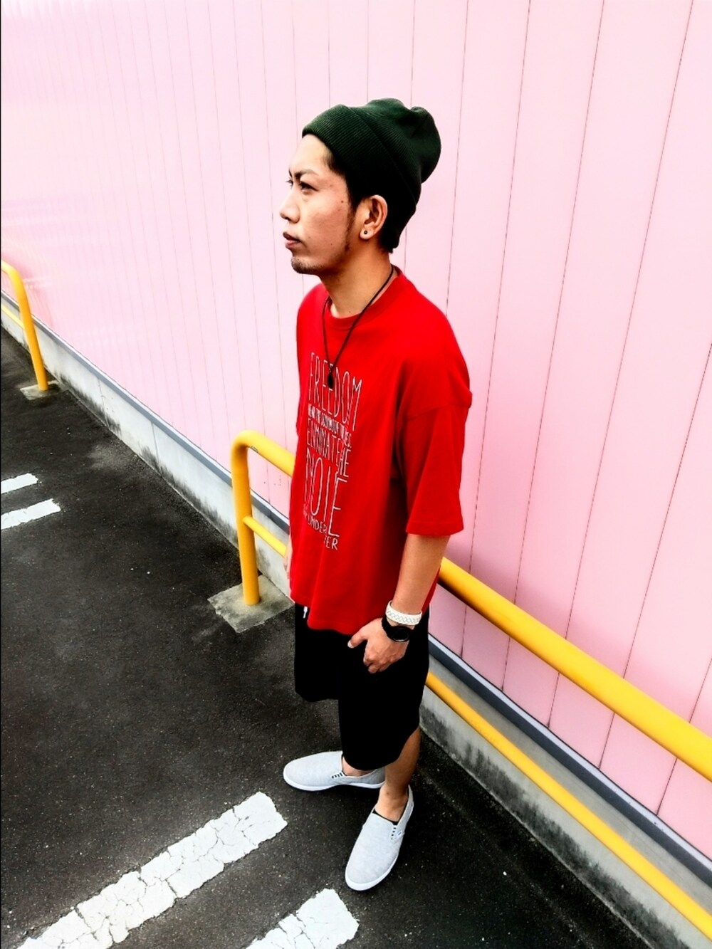 レッド系のTシャツ/カットソー、ブラック系のその他パンツ、グレー系のスニーカーを着用したメンズの夏コーディネートの2枚目の写真