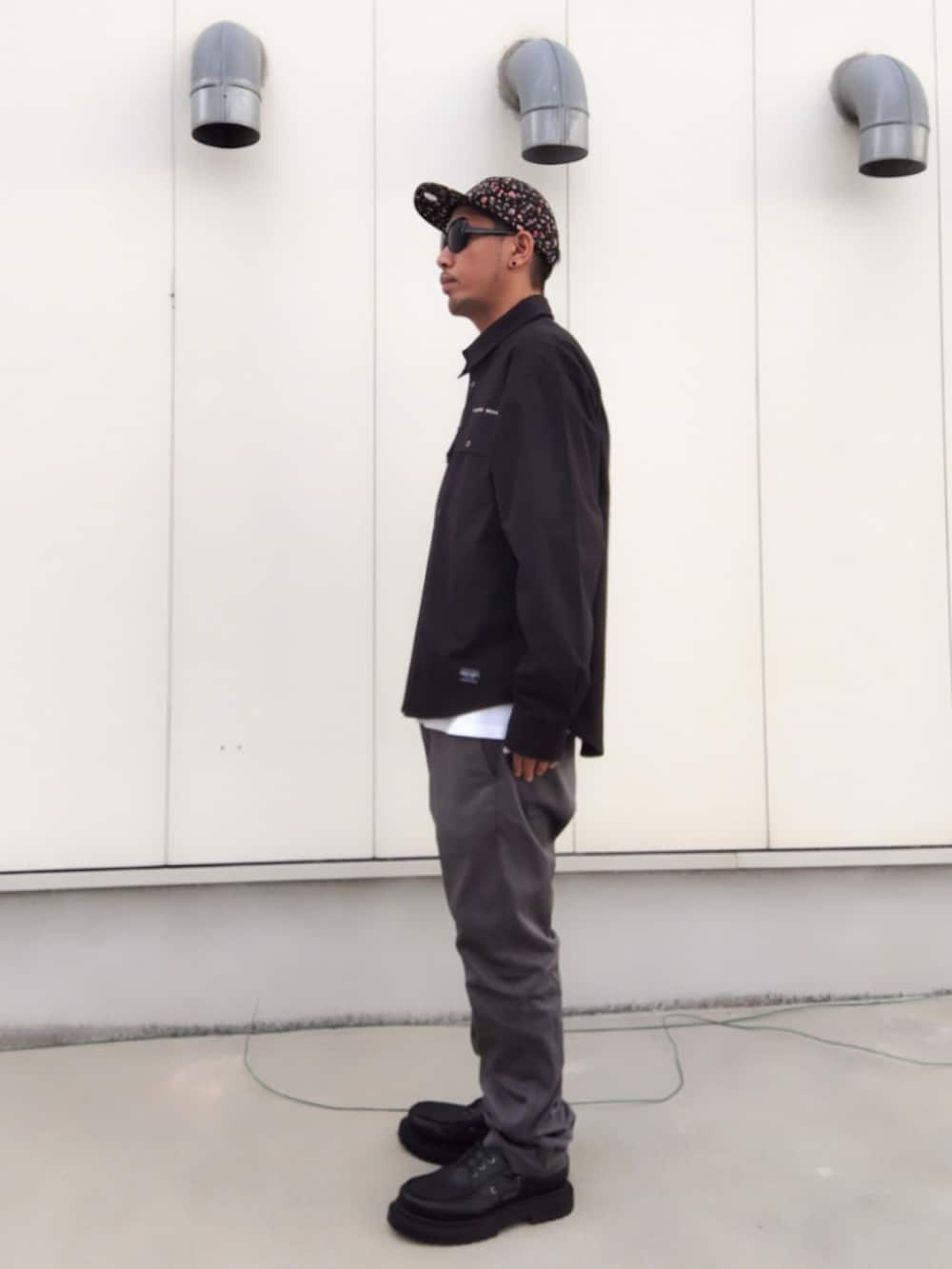 ブラック系のシャツ/ブラウス、グレー系のチノパンツ、ブラック系のモカシン/デッキシューズを着用したメンズの秋コーディネートの2枚目の写真