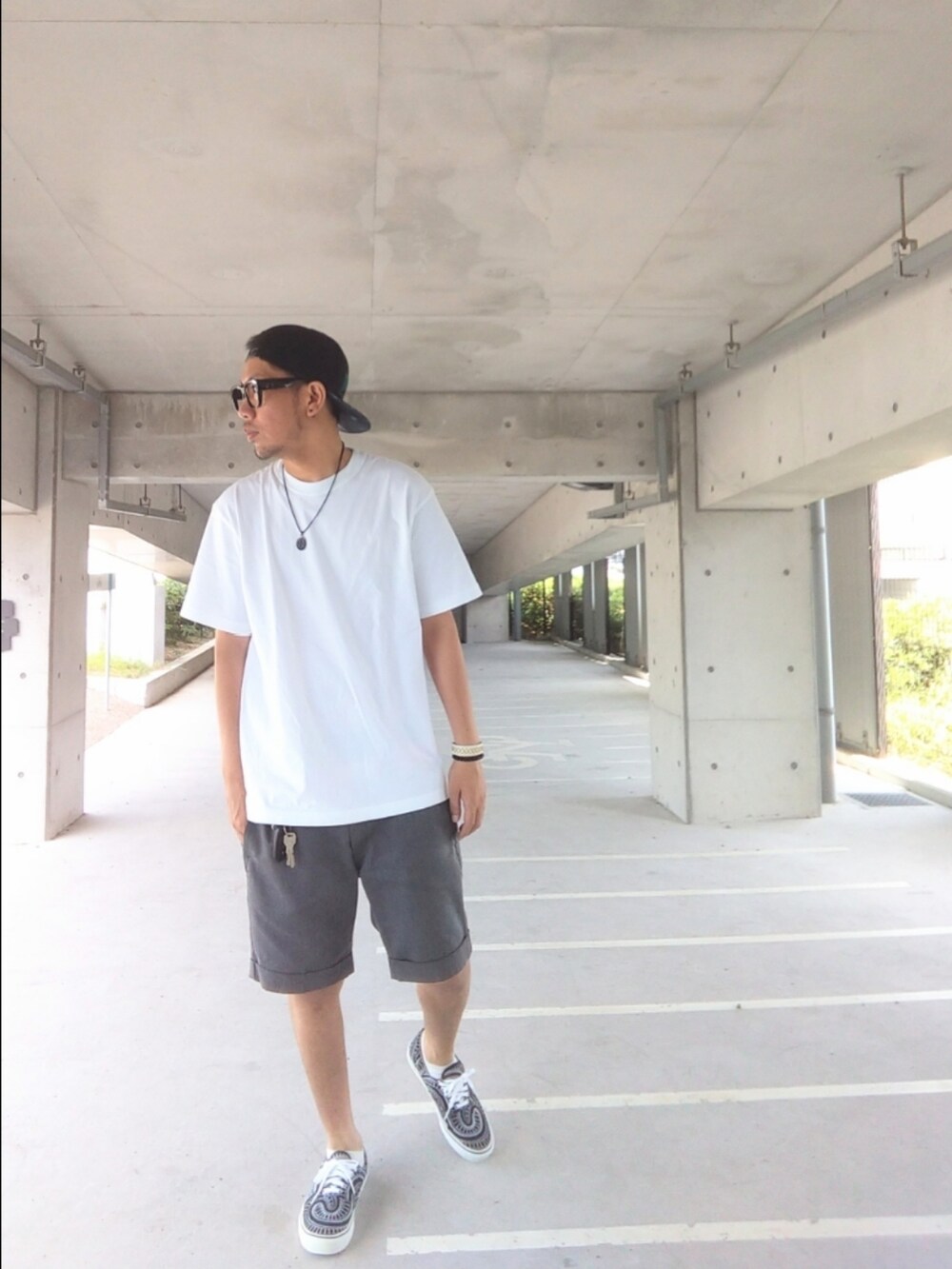 グレー系のその他パンツ、ブラック系のスニーカー、ホワイト系のTシャツ/カットソーを着用したメンズの夏コーディネートの2枚目の写真