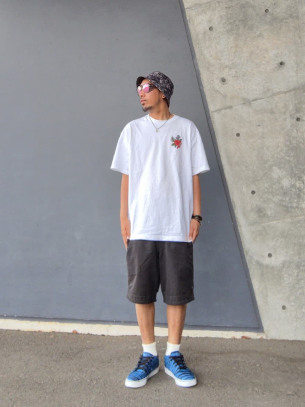 ホワイト系のTシャツ/カットソー、ブラック系のその他パンツ、ブルー系のスニーカーを着用したメンズの春コーディネートの2枚目の写真