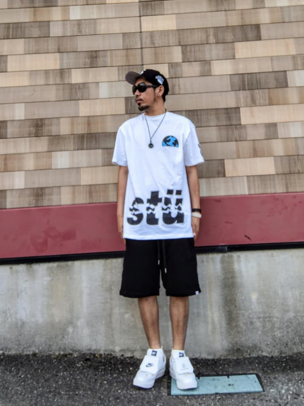ホワイト系のTシャツ/カットソー、ブラック系のその他パンツ、ホワイト系のスニーカーを着用したメンズの夏コーディネートの2枚目の写真