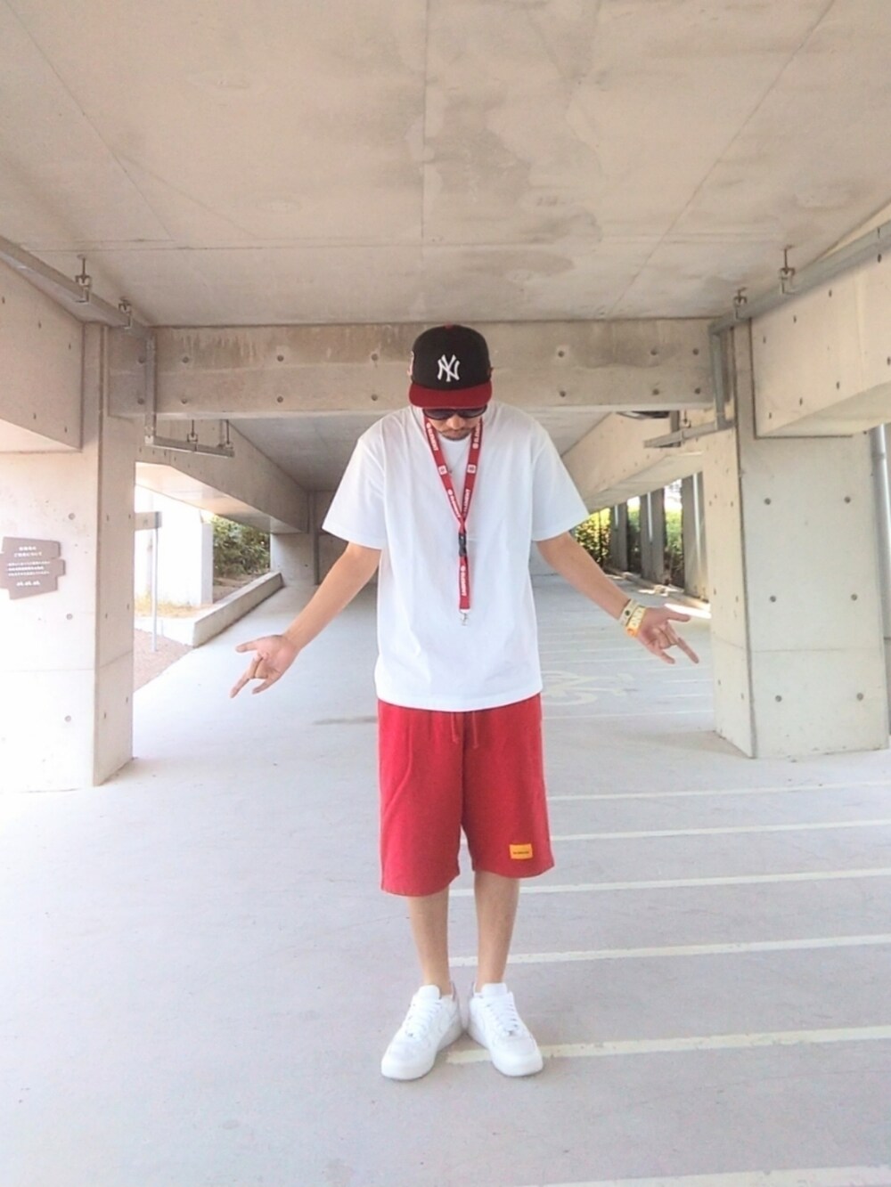 ホワイト系のTシャツ/カットソー、レッド系のその他パンツ、ホワイト系のスニーカーを着用したメンズの夏コーディネートの3枚目の写真