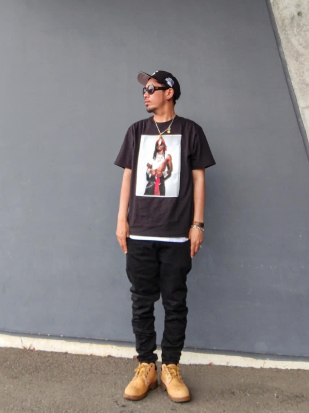 ブラック系のTシャツ/カットソー、ホワイト系のタンクトップ、ブラック系のデニムパンツを着用したメンズの夏コーディネートの2枚目の写真
