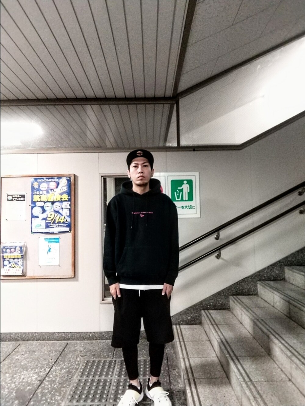 ブラック系のパーカー、ブラック系のその他パンツ、ホワイト系のスニーカーを着用したメンズの秋コーディネートの4枚目の写真