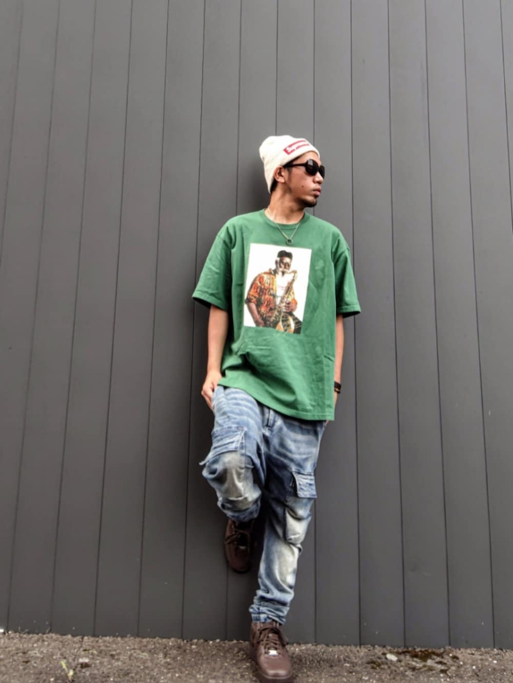 グリーン系のTシャツ/カットソー、ブルー系のデニムパンツ、ブラウン系のスニーカーを着用したメンズの秋コーディネートの2枚目の写真