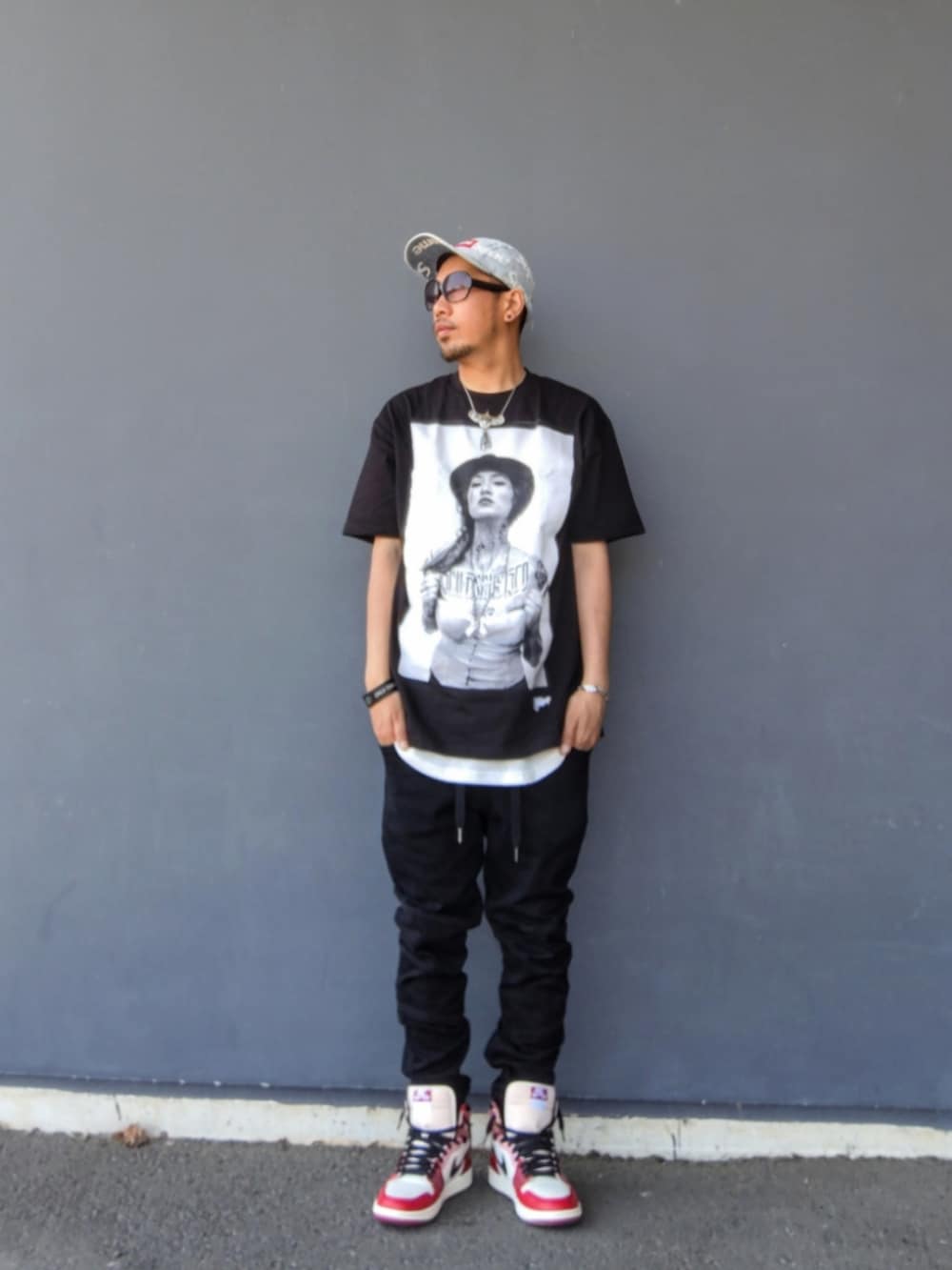 ブラック系のTシャツ/カットソー、ブラック系のデニムパンツ、レッド系のスニーカーを着用したメンズの春コーディネートの2枚目の写真