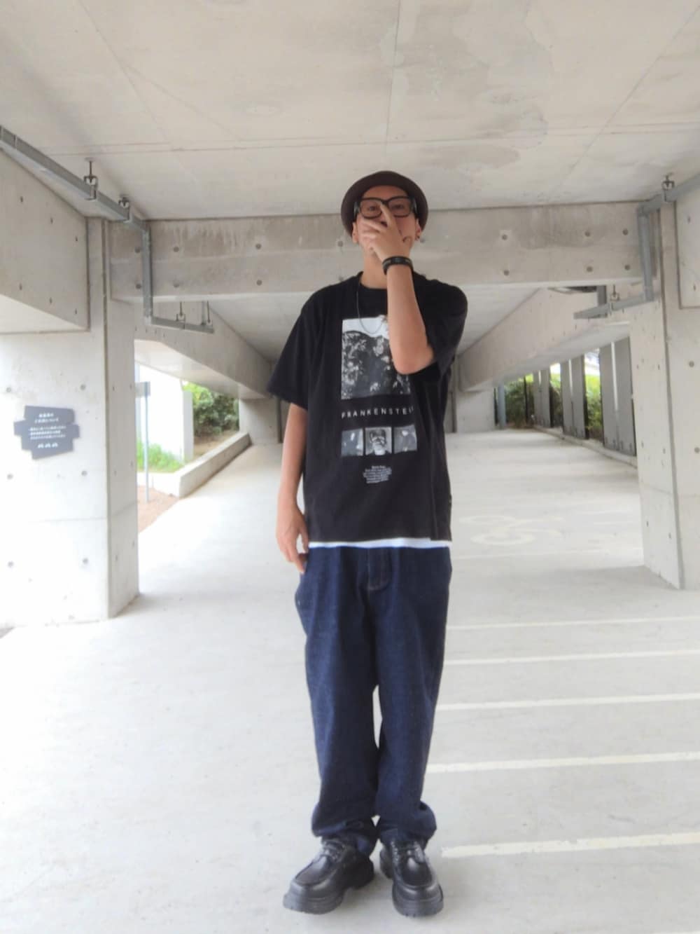 ブラック系のTシャツ/カットソー、ブルー系のデニムパンツ、ブラック系のモカシン/デッキシューズを着用したメンズの秋コーディネートの2枚目の写真