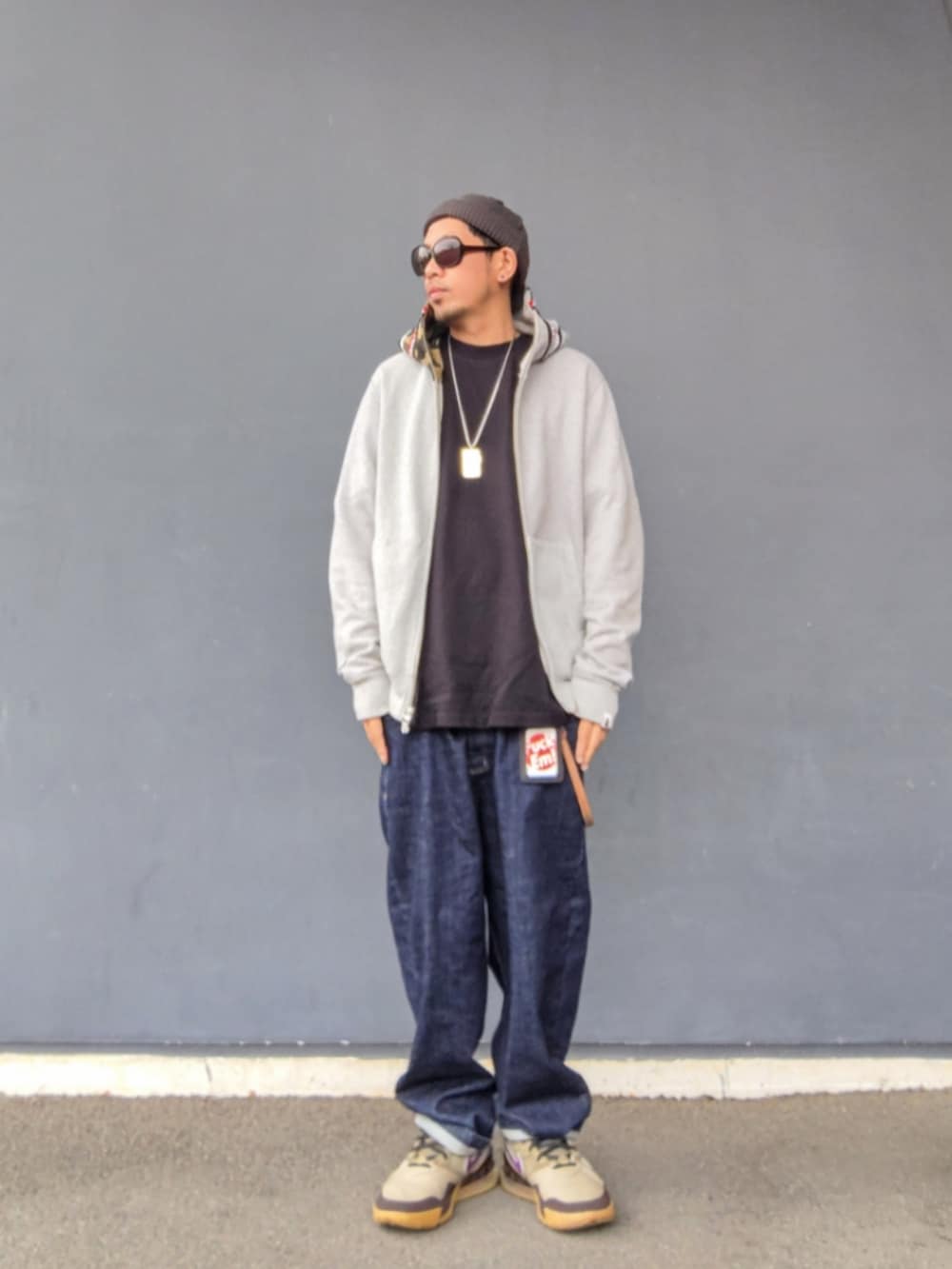 グレー系のパーカー、ブラック系のTシャツ/カットソー、ブルー系のデニムパンツを着用したメンズの春コーディネートの3枚目の写真