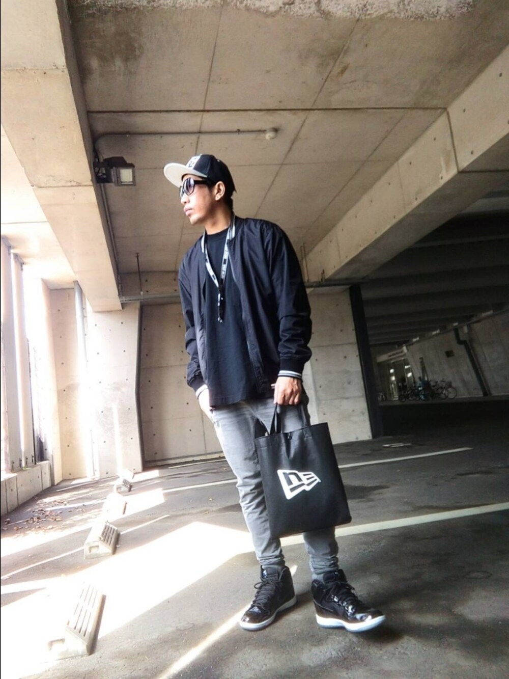 ブラック系のTシャツ/カットソー、その他のブルゾン、ブラック系のバッグを着用したメンズの春コーディネートの2枚目の写真