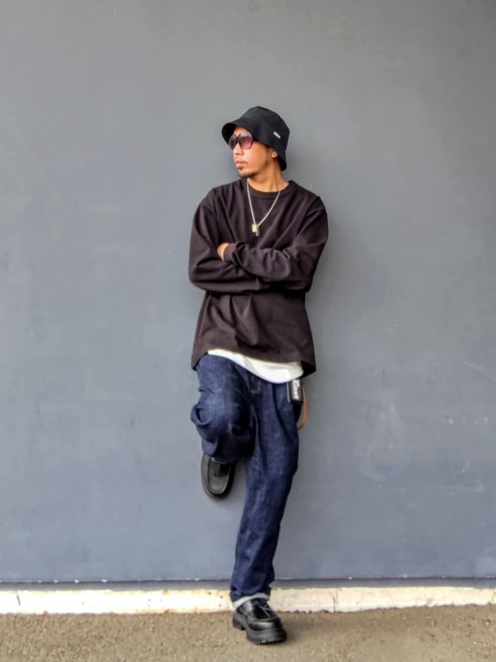 ブラック系のスウェット、ホワイト系のタンクトップ、ブルー系のデニムパンツを着用したメンズの春コーディネートの2枚目の写真