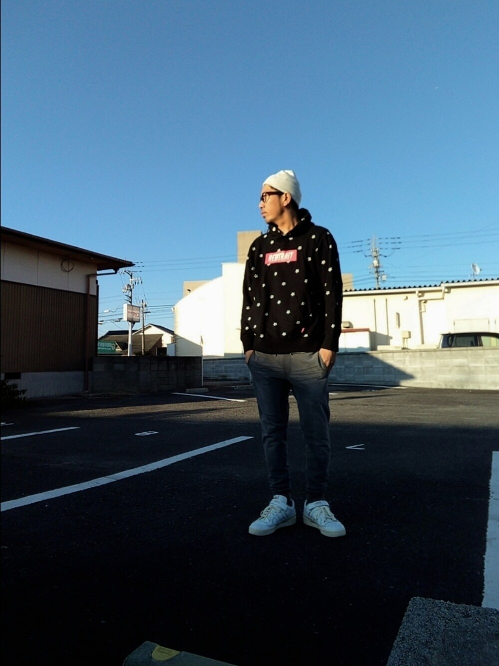 ブラック系のパーカー、ホワイト系のスニーカー、グレー系のその他パンツを着用したメンズの秋コーディネートの3枚目の写真