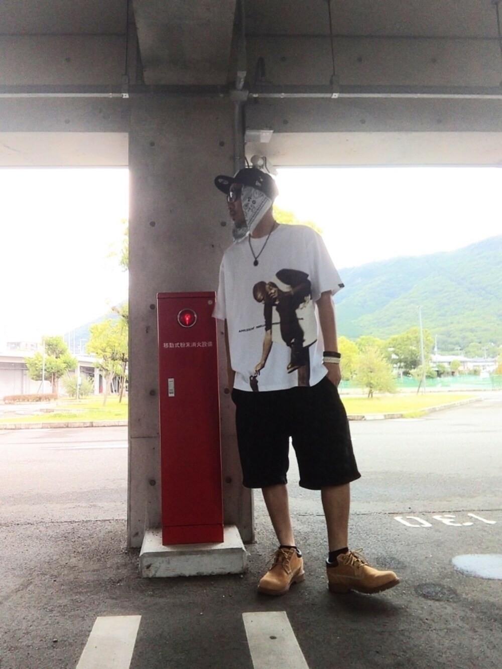 ホワイト系のTシャツ/カットソー、ブラック系のパンツ、イエロー系のブーツを着用したメンズの夏コーディネートの3枚目の写真