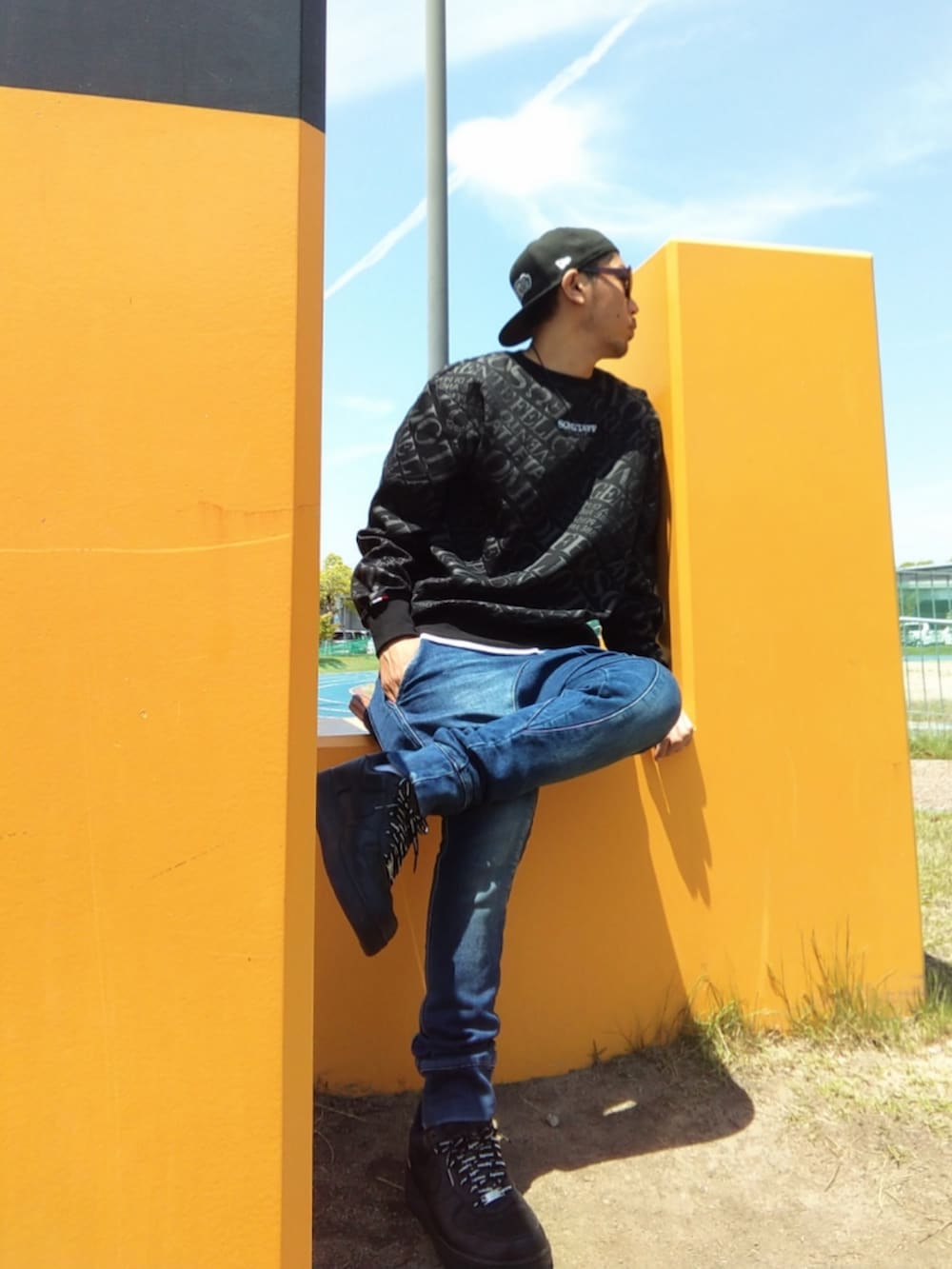 ブラック系のスウェット、ホワイト系のタンクトップ、ブルー系のパンツを着用したメンズの春コーディネートの2枚目の写真