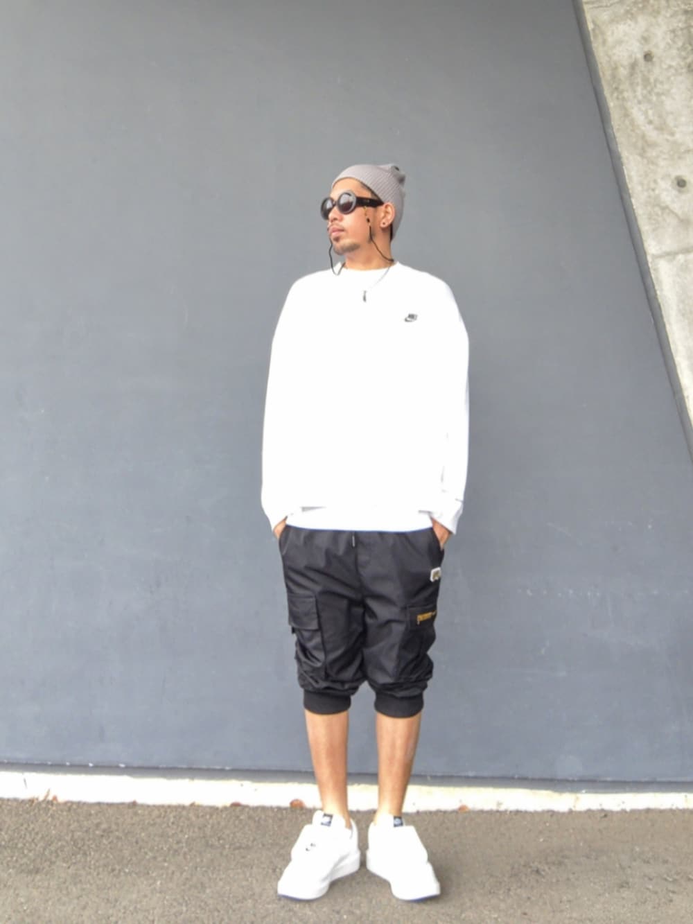 ホワイト系のTシャツ/カットソー、ブラック系のカーゴパンツ、ホワイト系のスニーカーを着用したメンズの夏コーディネートの2枚目の写真