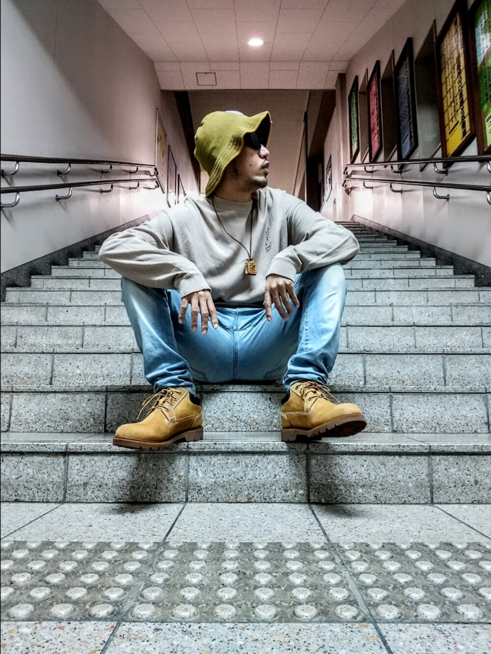 ベージュ系のTシャツ/カットソー、ブルー系のデニムパンツ、イエロー系のブーツを着用したメンズの秋コーディネートの3枚目の写真