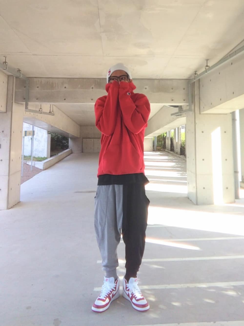 レッド系のパーカー、ブラック系のTシャツ/カットソー、その他のスウェットパンツを着用したメンズの秋コーディネートの4枚目の写真