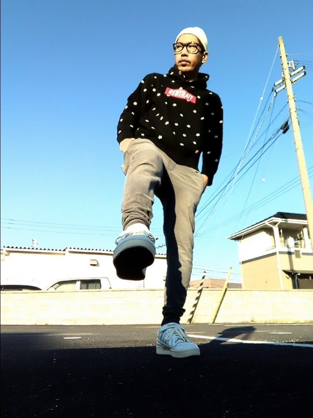 ブラック系のパーカー、ホワイト系のスニーカー、グレー系のその他パンツを着用したメンズの秋コーディネートの2枚目の写真