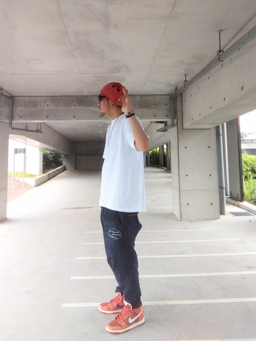 ホワイト系のTシャツ/カットソー、ブルー系のデニムパンツ、オレンジ系のスニーカーを着用したメンズの夏コーディネートの3枚目の写真