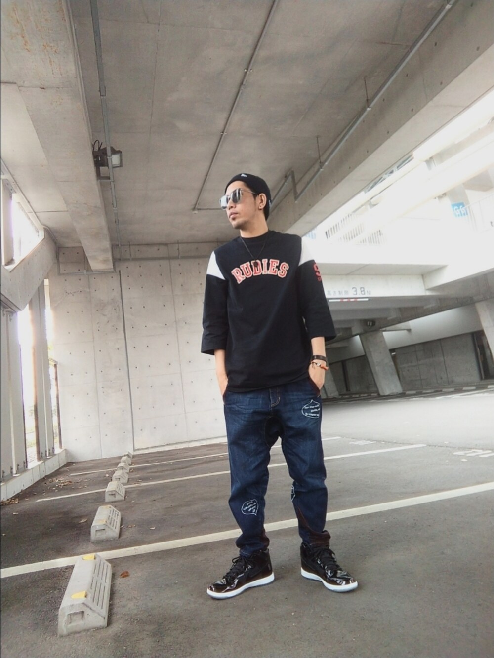 ブラック系のTシャツ/カットソー、ブルー系のデニムパンツ、ブラック系のスニーカーを着用したメンズの春コーディネートの2枚目の写真