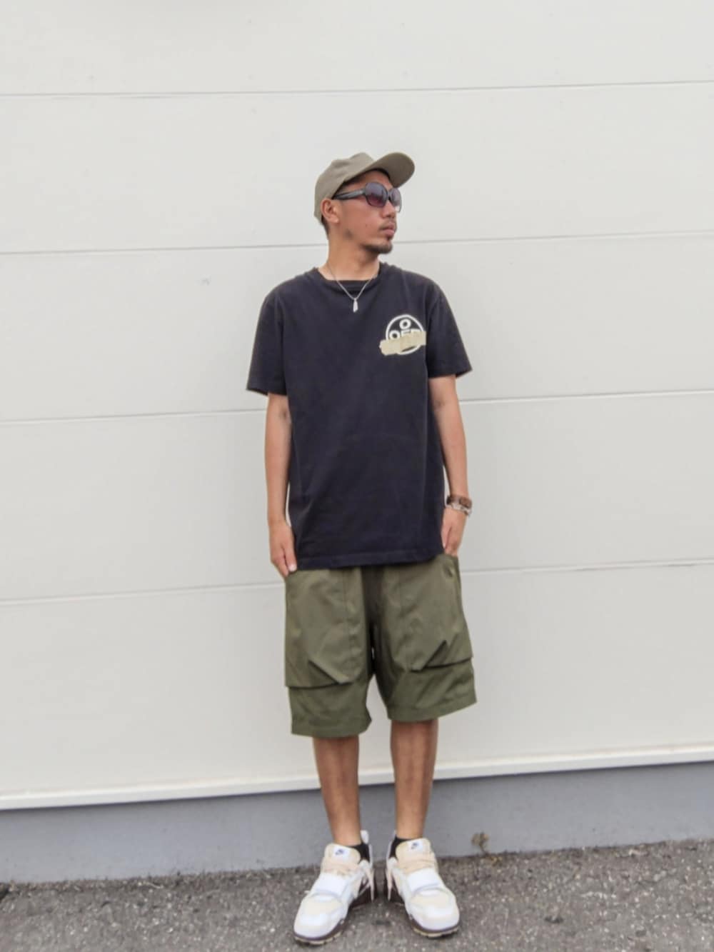 ブラック系のTシャツ/カットソー、グリーン系のその他パンツ、ブラウン系のスニーカーを着用したメンズの夏コーディネートの2枚目の写真