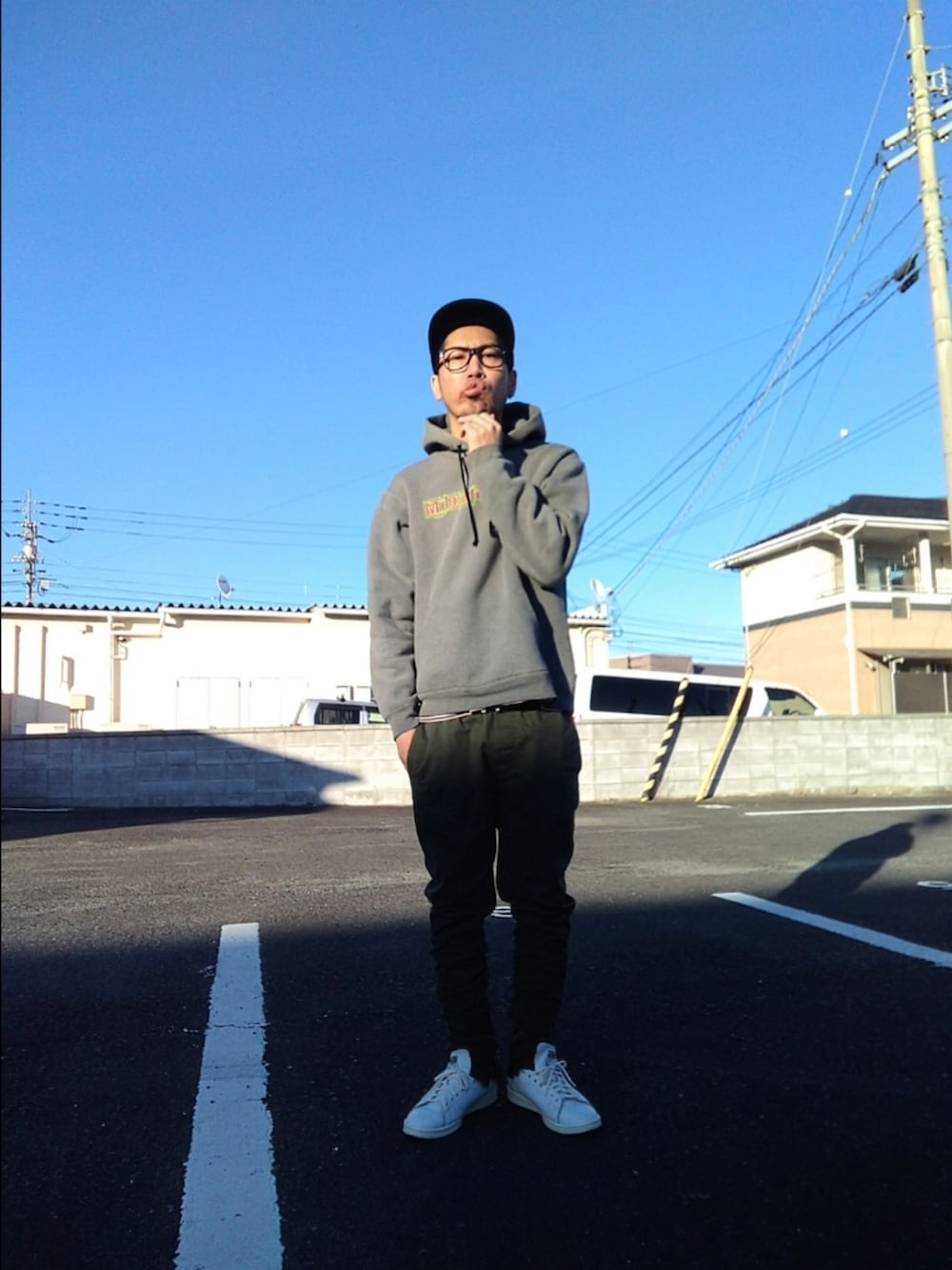 グレー系のパーカー、グリーン系のパンツ、ホワイト系のスニーカーを着用したメンズの冬コーディネートの2枚目の写真