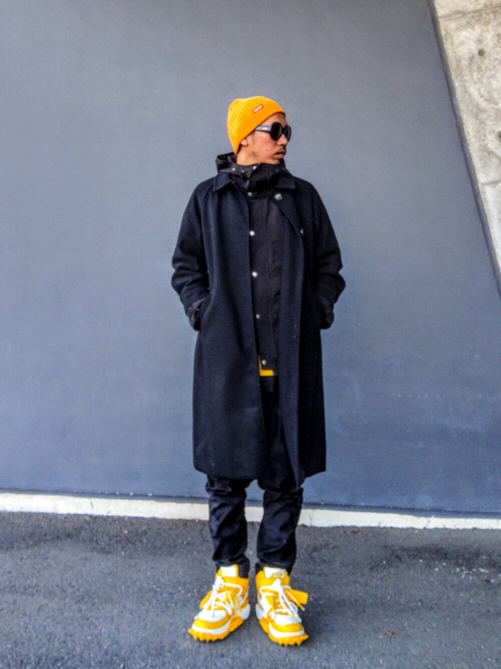 ブラック系のマウンテンパーカー、イエロー系のTシャツ/カットソー、ブラック系のパンツを着用したメンズの冬コーディネートの3枚目の写真