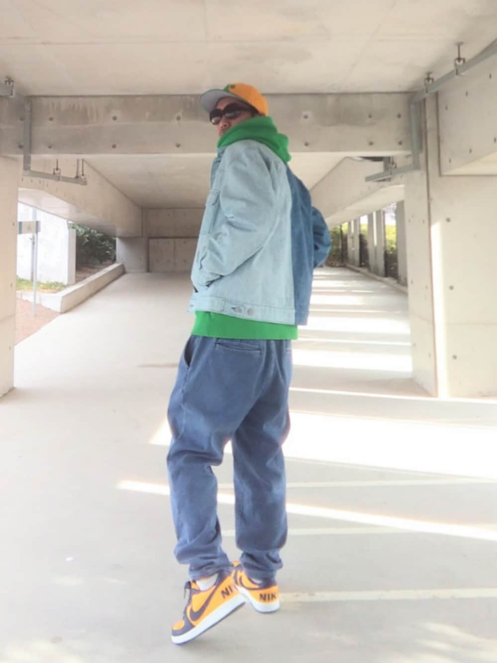 ブルー系のデニムジャケット、グリーン系のパーカー、ブルー系のデニムパンツを着用したメンズの冬コーディネートの2枚目の写真