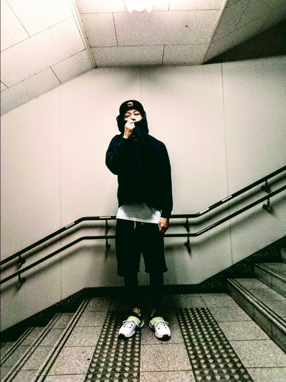 ブラック系のパーカー、ブラック系のその他パンツ、ホワイト系のスニーカーを着用したメンズの秋コーディネートの2枚目の写真