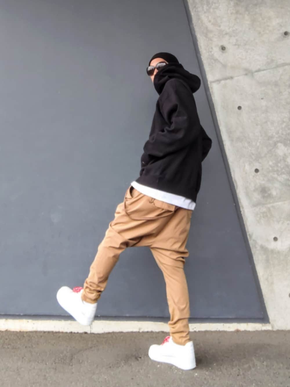 ブラック系のパーカー、ベージュ系のその他パンツ、ホワイト系のスニーカーを着用したメンズの春コーディネートの2枚目の写真