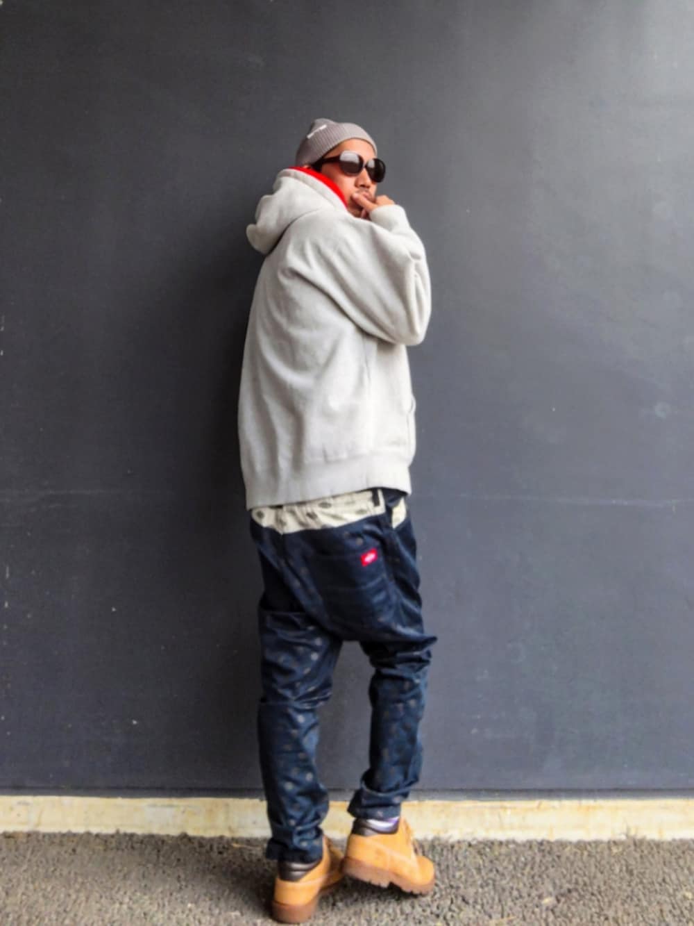 グレー系のパーカー、ブルー系のその他パンツ、イエロー系のブーツを着用したメンズの冬コーディネートの3枚目の写真