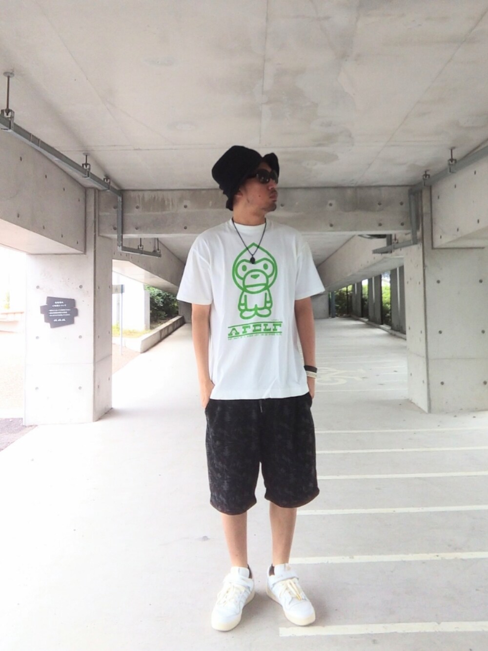 ホワイト系のTシャツ/カットソー、ブラック系のパンツ、ホワイト系のスニーカーを着用したメンズの夏コーディネートの3枚目の写真