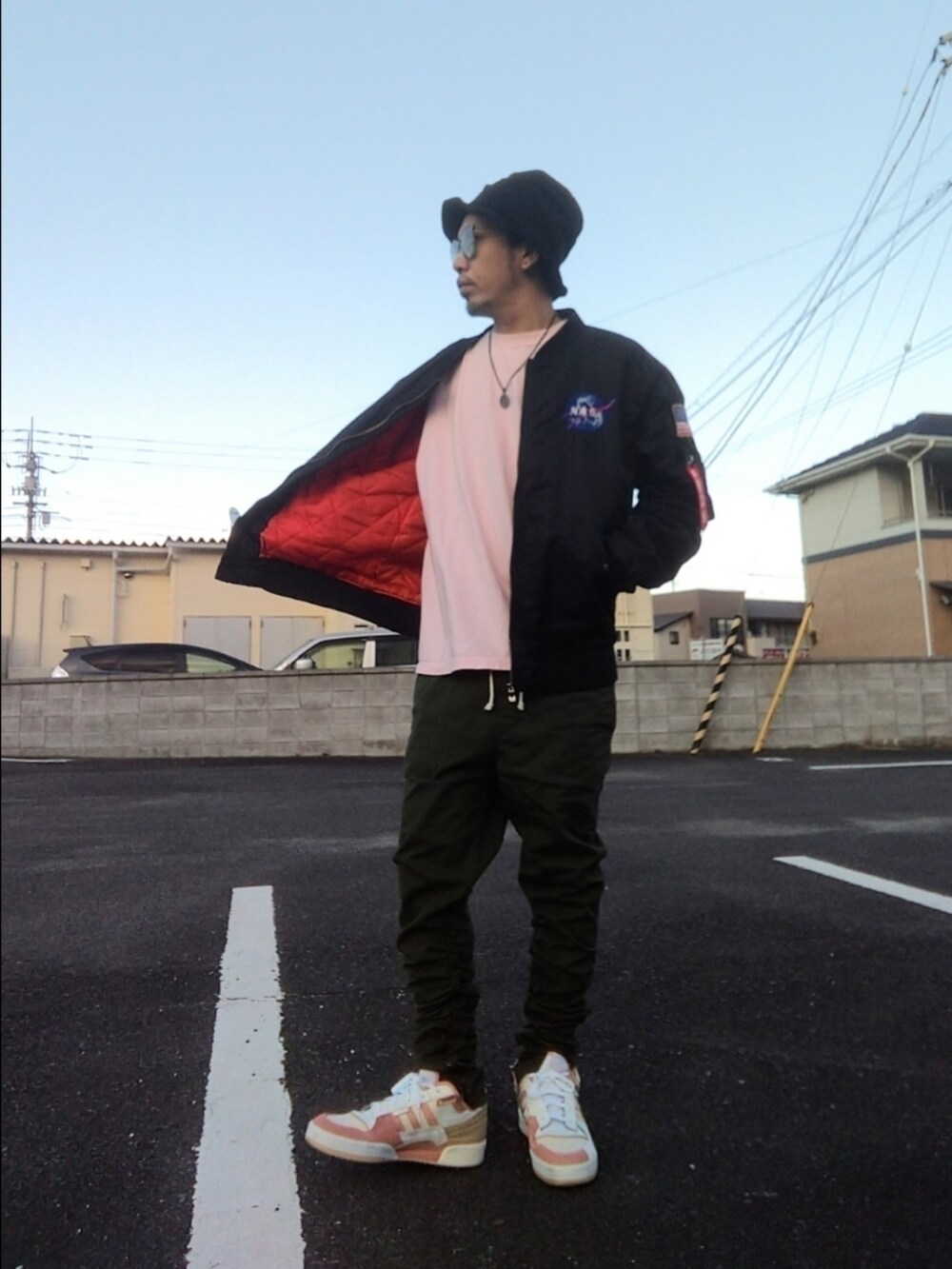 ブラック系のMA-1、ピンク系のTシャツ/カットソー、グリーン系のパンツを着用したメンズの冬コーディネートの3枚目の写真