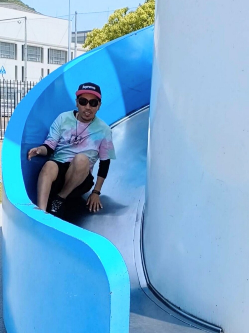 ピンク系のTシャツ/カットソー、ブラック系のその他パンツ、ブラック系のスニーカーを着用したメンズの春コーディネートの3枚目の写真