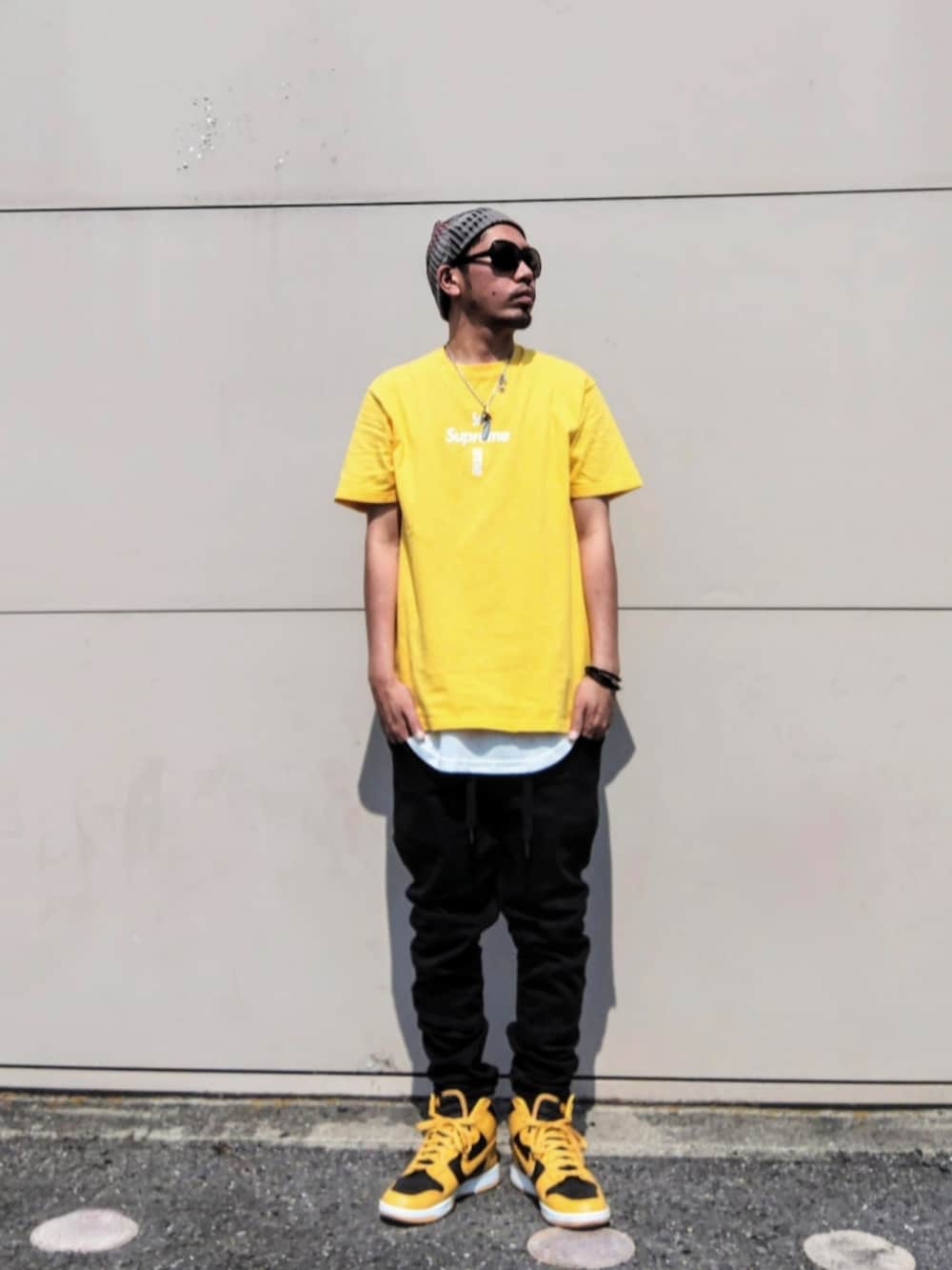 イエロー系のTシャツ/カットソー、ホワイト系のタンクトップ、ブラック系のデニムパンツを着用したメンズの夏コーディネートの2枚目の写真
