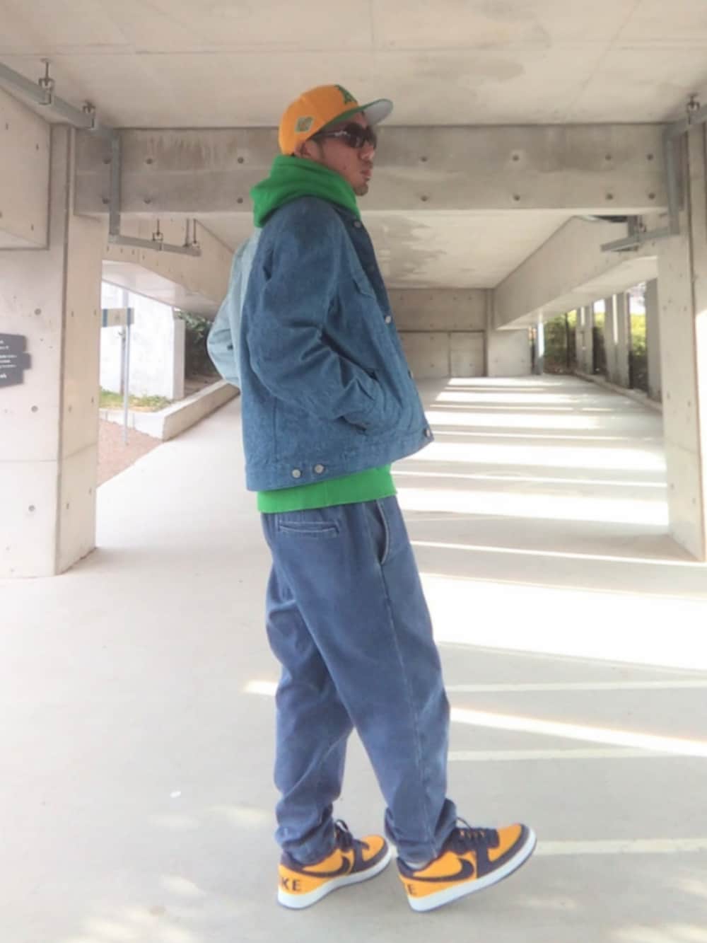 ブルー系のデニムジャケット、グリーン系のパーカー、ブルー系のデニムパンツを着用したメンズの冬コーディネートの3枚目の写真