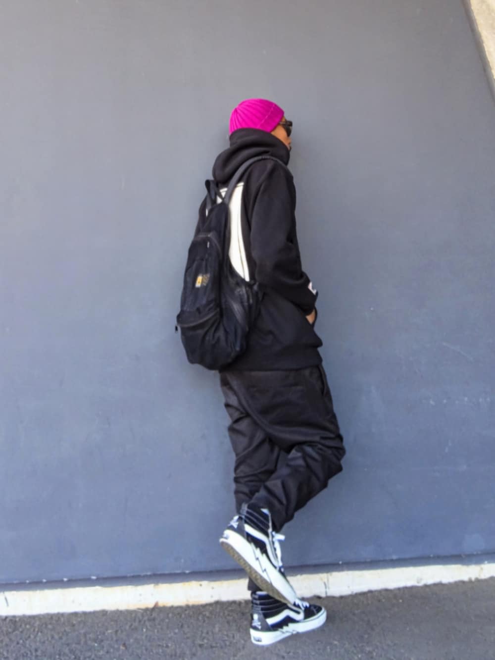 ブラック系のパーカー、ブラック系のバックパック/リュック、ブラック系のパンツを着用したメンズの冬コーディネートの3枚目の写真