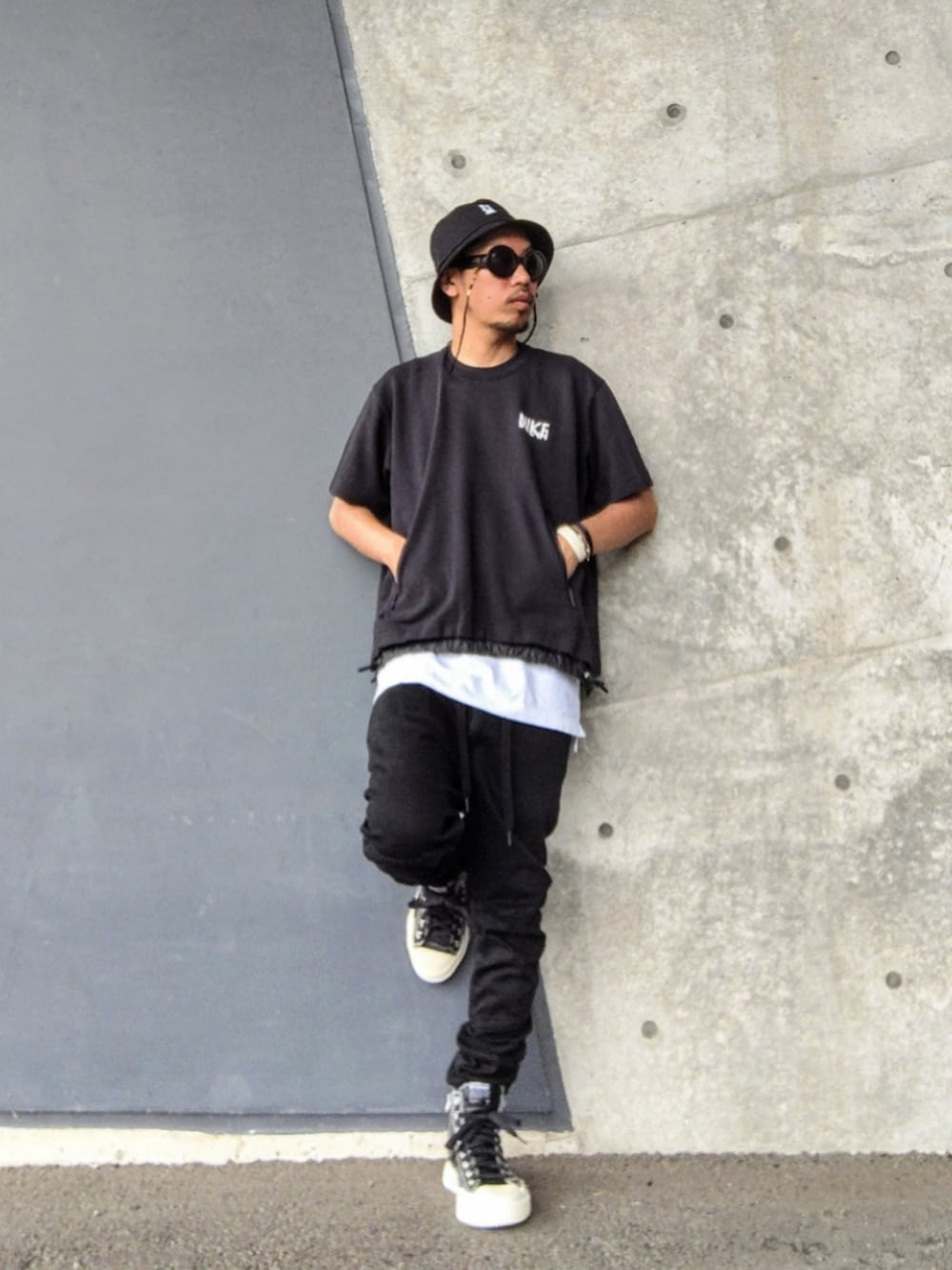 ブラック系のTシャツ/カットソー、ホワイト系のタンクトップ、ブラック系のデニムパンツを着用したメンズの夏コーディネートの2枚目の写真