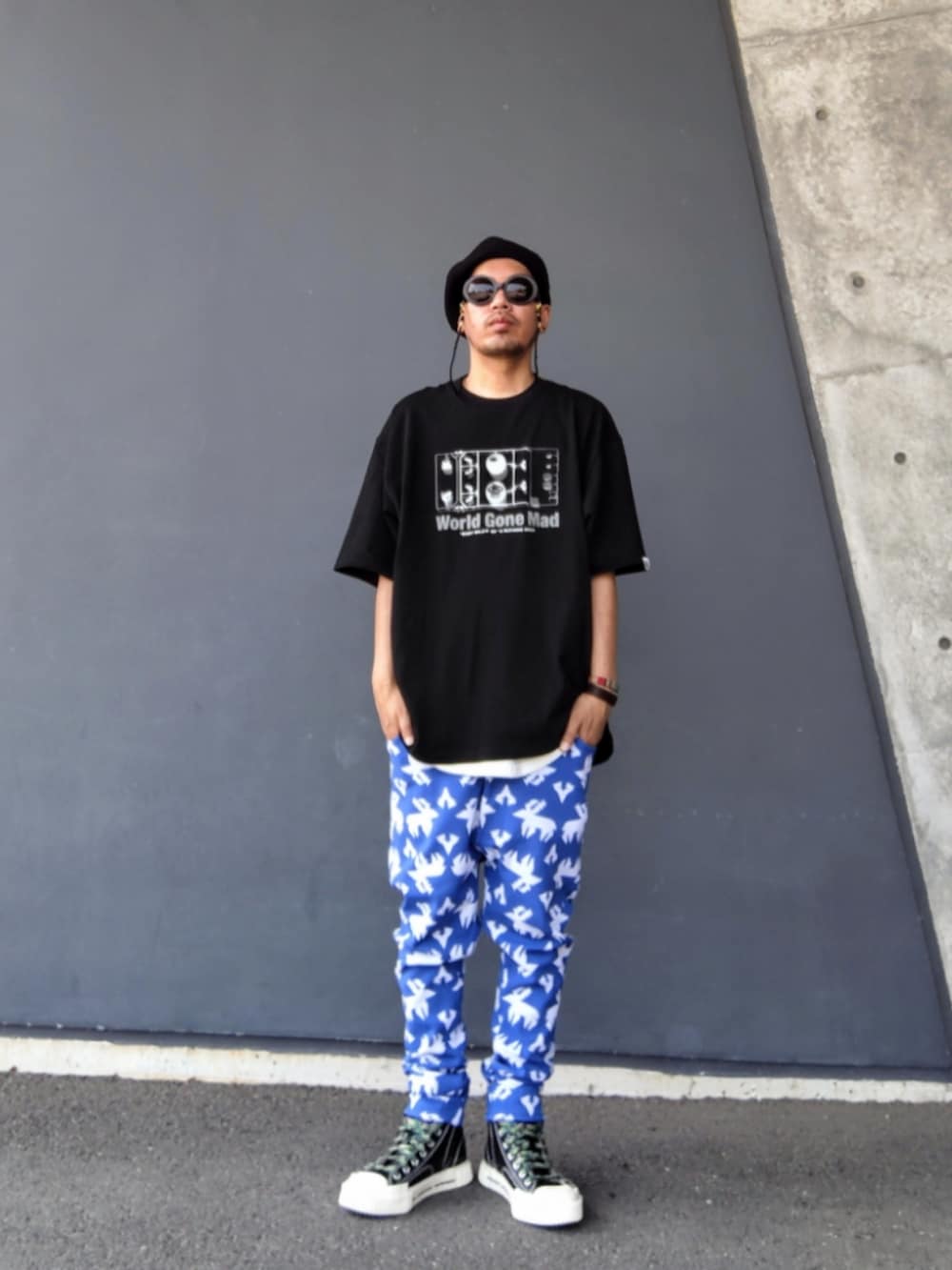 ブラック系のTシャツ/カットソー、ブルー系のその他パンツ、ブラック系のスニーカーを着用したメンズの夏コーディネートの2枚目の写真
